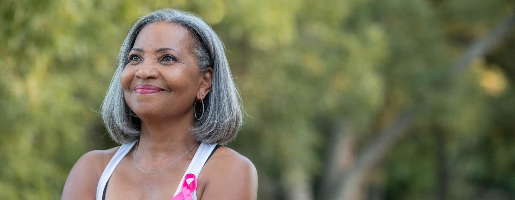 a woman with grey hair smiles to herself in neighborhood park