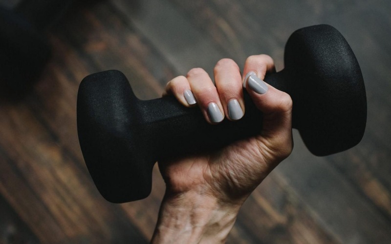 a person's hand holding a dumbbell